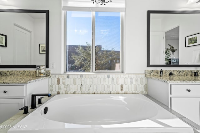 bathroom featuring a garden tub and vanity