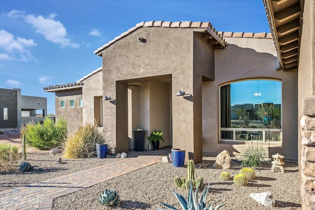 view of front facade with a tile roof and stucco siding