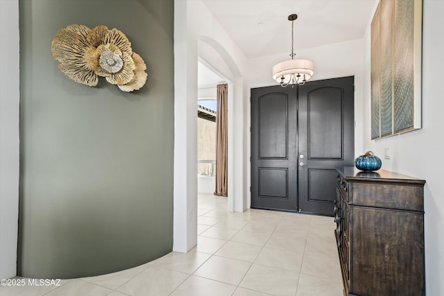 foyer entrance featuring light tile patterned floors and a notable chandelier