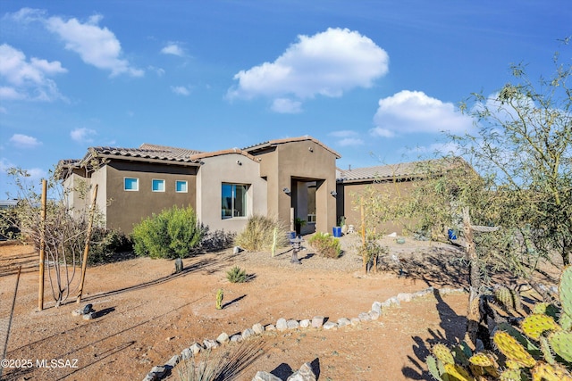 view of front of property featuring a tile roof and stucco siding