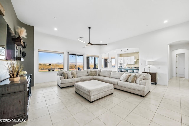 living room featuring arched walkways, ceiling fan, light tile patterned floors, and recessed lighting