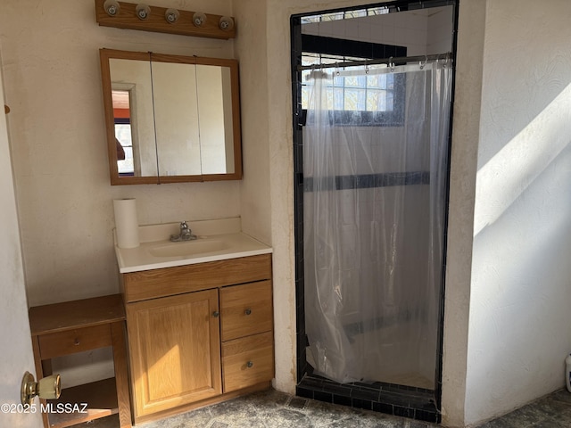 bathroom featuring walk in shower and vanity