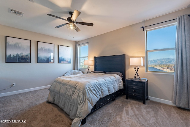 carpeted bedroom with a mountain view and ceiling fan