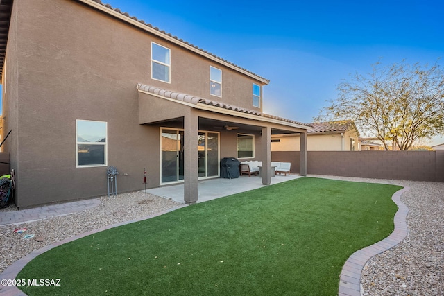 rear view of property featuring a patio and a lawn