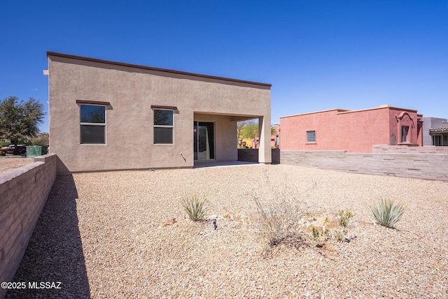 rear view of house featuring a patio area and stucco siding