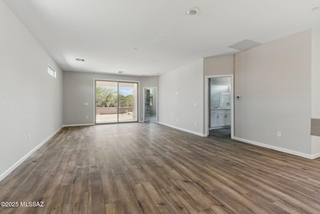 spare room featuring visible vents, dark wood-type flooring, and baseboards