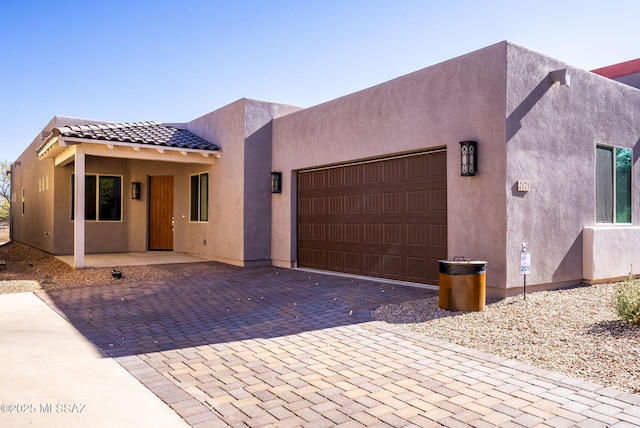 pueblo revival-style home with a garage