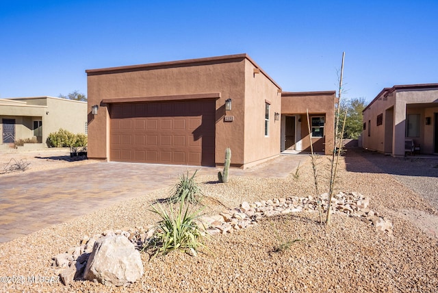 pueblo-style house featuring a garage