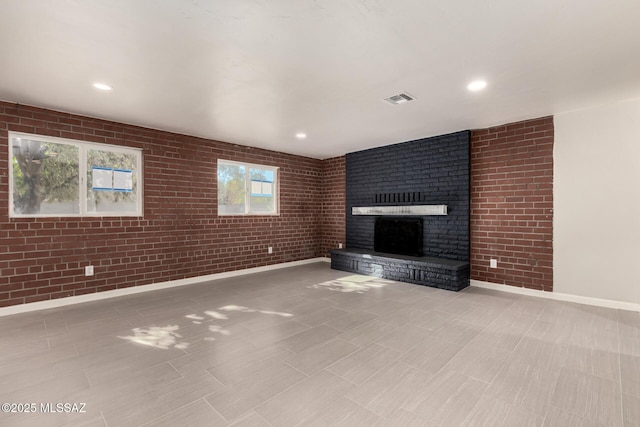 unfurnished living room with a brick fireplace and brick wall