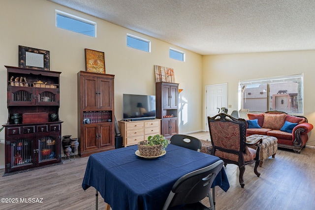 dining area featuring a textured ceiling and light wood-style flooring