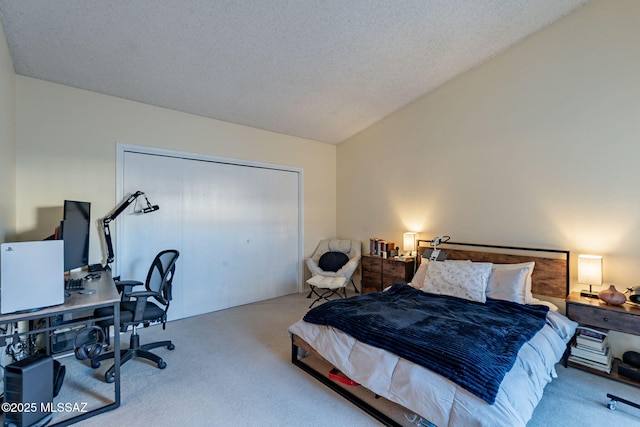 bedroom with lofted ceiling, carpet floors, a textured ceiling, and a closet