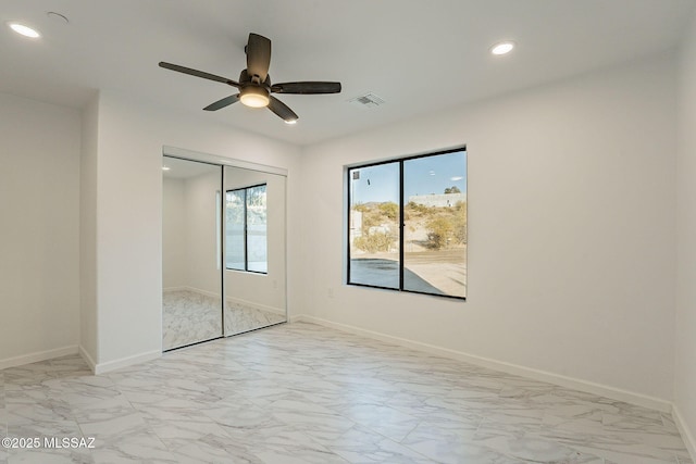 unfurnished bedroom featuring ceiling fan and a closet