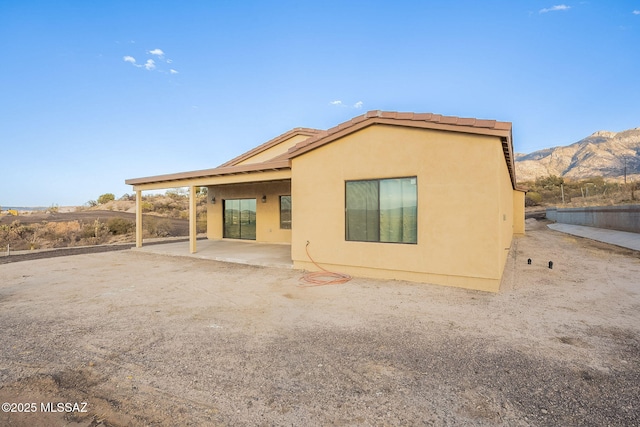 rear view of property featuring a mountain view and a patio