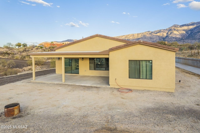 back of house featuring a mountain view and a patio