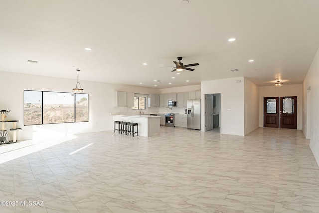 unfurnished living room featuring ceiling fan