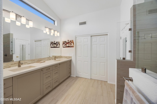 bathroom featuring a shower with door, a high ceiling, and vanity