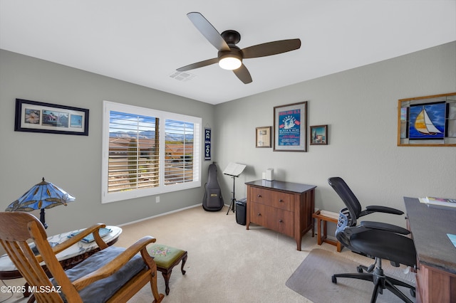 carpeted home office featuring ceiling fan