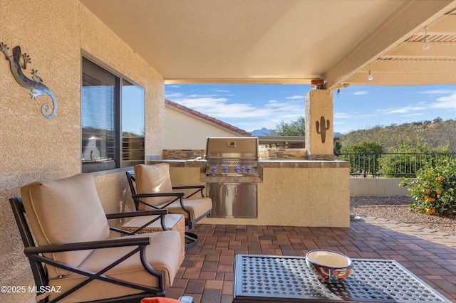 view of patio with an outdoor kitchen and a grill