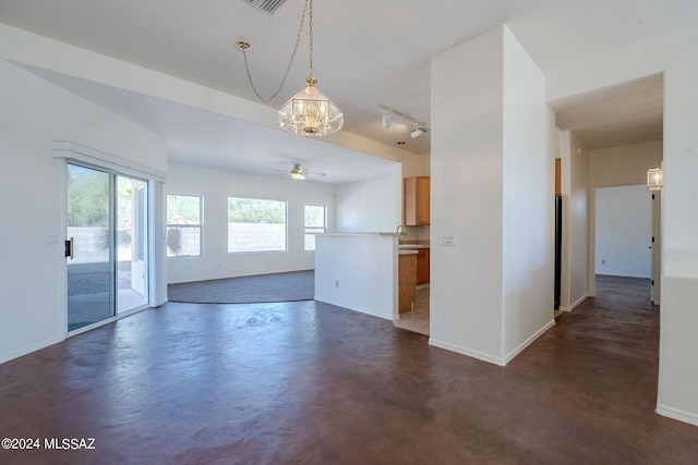 interior space featuring a wealth of natural light and ceiling fan with notable chandelier