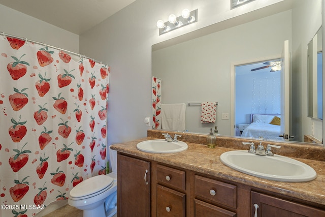 bathroom with curtained shower, vanity, ceiling fan, toilet, and tile patterned floors