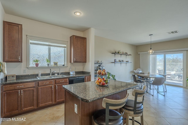 kitchen with a kitchen island, pendant lighting, dishwasher, sink, and a kitchen bar