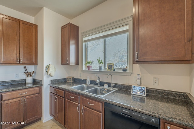 kitchen with dark stone countertops, sink, light tile patterned floors, and dishwasher