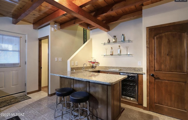 bar with wine cooler, beam ceiling, light stone countertops, and wooden ceiling