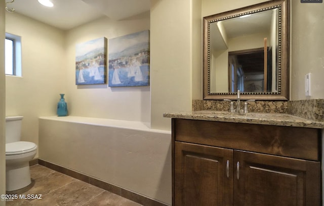 bathroom with vanity, a bath, tile patterned floors, and toilet