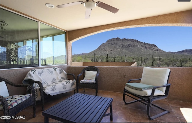 view of patio / terrace with a balcony, a mountain view, and ceiling fan