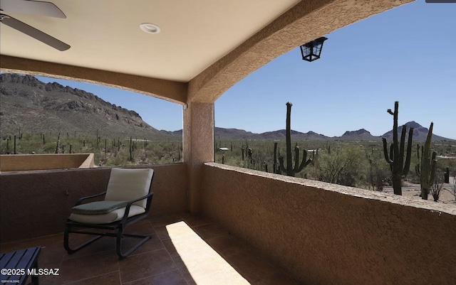 balcony featuring ceiling fan and a mountain view