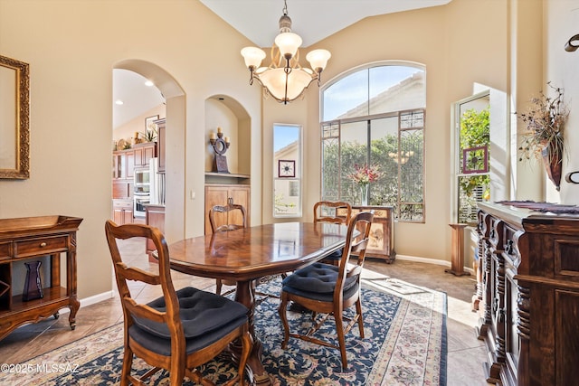 dining area with lofted ceiling and a notable chandelier