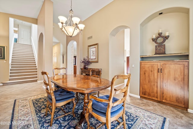dining area with light tile patterned floors and a notable chandelier