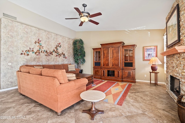 living room with a stone fireplace, lofted ceiling, and ceiling fan