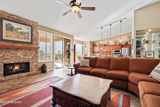 living room with vaulted ceiling, a fireplace, ceiling fan with notable chandelier, and light tile patterned floors