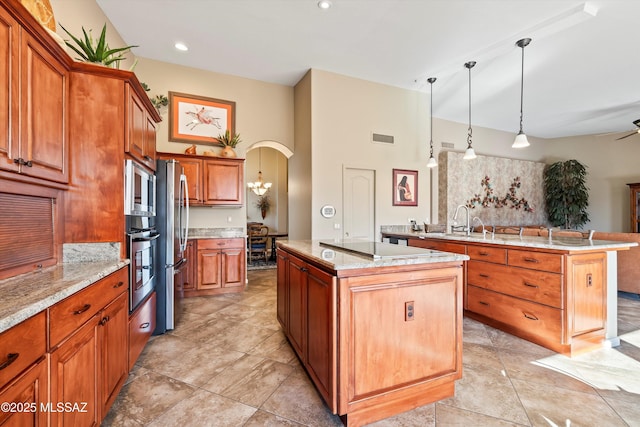 kitchen featuring hanging light fixtures, appliances with stainless steel finishes, a kitchen island with sink, and sink