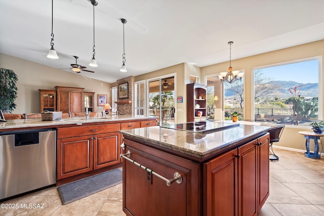 kitchen with light stone counters, a center island, hanging light fixtures, dishwasher, and a mountain view