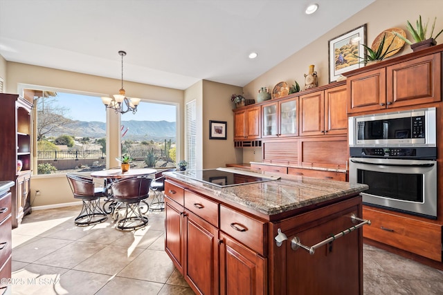 kitchen featuring pendant lighting, a center island, a mountain view, stainless steel appliances, and light stone countertops