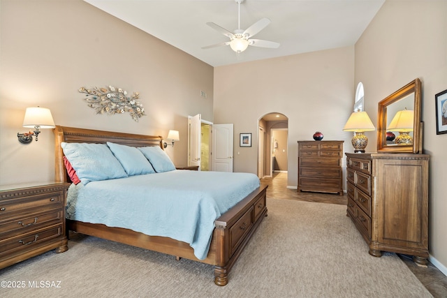 carpeted bedroom featuring ceiling fan and high vaulted ceiling
