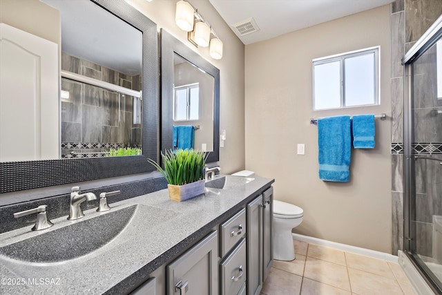 bathroom with vanity, tile patterned flooring, a shower with shower door, and toilet