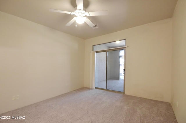 unfurnished bedroom featuring a closet, light colored carpet, and ceiling fan