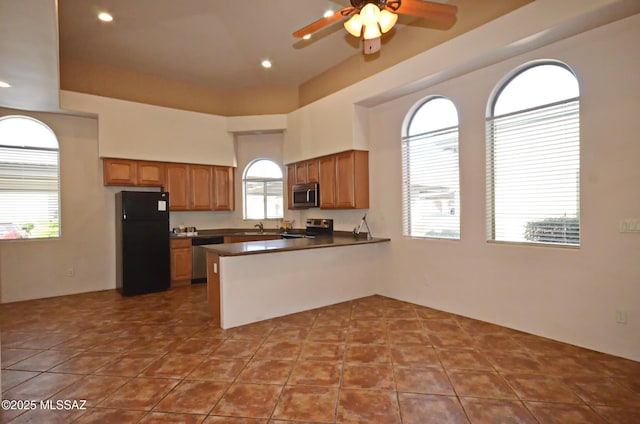 kitchen with plenty of natural light, stainless steel appliances, tile patterned flooring, and kitchen peninsula