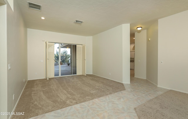 carpeted empty room featuring a textured ceiling