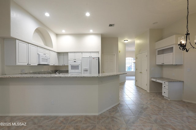 kitchen featuring hanging light fixtures, kitchen peninsula, white appliances, light stone countertops, and white cabinets