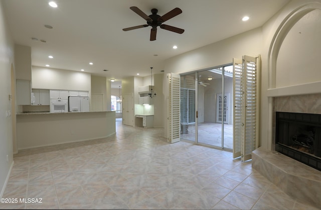 unfurnished living room with a fireplace and ceiling fan