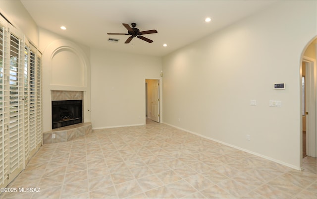 unfurnished living room with light tile patterned floors, a fireplace, and ceiling fan