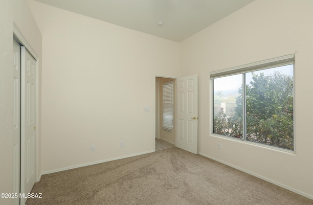 unfurnished bedroom with light carpet and a closet