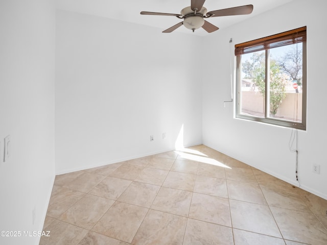 unfurnished room featuring light tile patterned floors, baseboards, and a ceiling fan