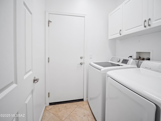 laundry area featuring cabinet space, light tile patterned floors, and independent washer and dryer