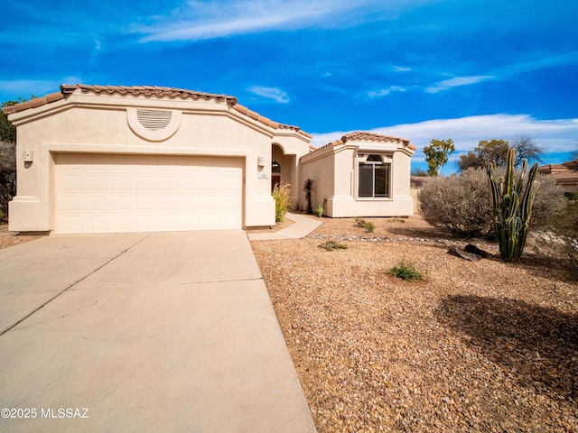 mediterranean / spanish-style house featuring driveway, a tiled roof, an attached garage, and stucco siding