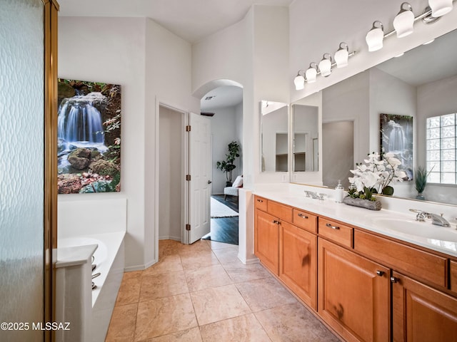 full bath with tile patterned flooring, a sink, a bath, and double vanity